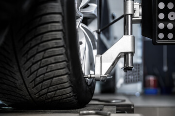 CLose-up car wheel indoors service maintenance repair center against laser sensor equipment...