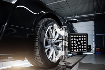 CLose-up car wheel indoors service maintenance repair center against laser sensor equipment...