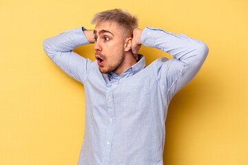 Young caucasian man isolated on yellow background screaming, very excited, passionate, satisfied with something.