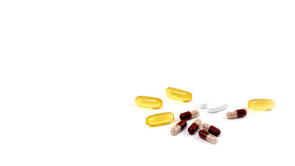 Composition with pills on the table. Heap of open medicines on a white paper background.