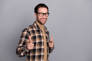 Photo of pretty excited man wear plaid shirt spectacles pointing you empty space isolated grey color background