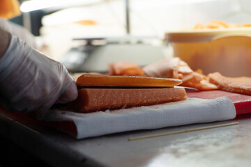 chef cuts a red fish with a knife on a cutting board in a restaurant for a beautiful presentation