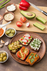 Healthy fast food. Different  homemade vegan, vegetarian sandwiches with vegetables and greens on bread on plate on kitchen