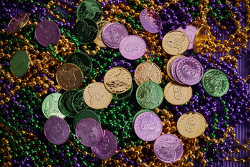 Green, gold, and purple Mardi Gras beads and coins background