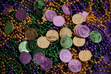 Green, gold, and purple Mardi Gras beads and coins background © vetre