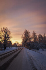Fototapeta na wymiar rural landscape tree cloudy morning sunset cold winter with snow and road