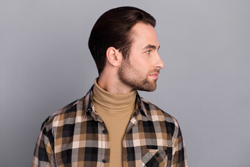 Photo of attractive charming man wear plaid shirt looking empty space isolated grey color background