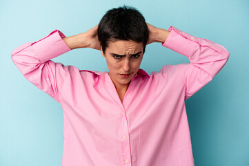 Young caucasian woman isolated on blue background screaming, very excited, passionate, satisfied with something.