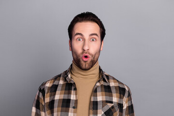 Photo of charming shocked guy dressed checkered shirt big eyes isolated grey color background