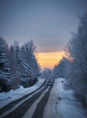 Fototapeta premium sunrise with clouds cold winter morning with snowy asphalt road
