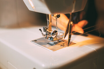 Scissors cutting a sewing machine thread