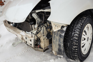 Disassembled damaged car after an accident on the street. Deformed hood. Without headlights and bumper