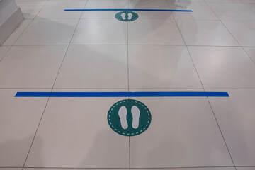 social distancing, keep the distance prevention floor sticker sign with two meters blue line, footsteps circle for queues in a mall shop