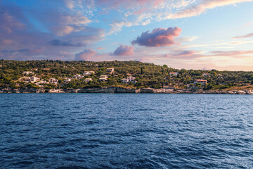 Naklejka premium Corfu island with buildings scattered on hills at sunset