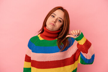 Young caucasian woman isolated on pink background showing a dislike gesture, thumbs down. Disagreement concept.