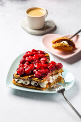 Heart shaped cake with cream and raspberries with cup of coffee on concrete background. Millefeuille or mille feuille, lovely french dessert for Valentine's day.