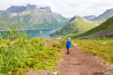Fototapeta na wymiar Happy family, standing on a rock and looking over Segla mountain on Senja island, North Norway. Amazing beautiful landscape and splendid nature