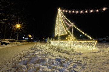 winter lights decorations in small town in the evening with snow