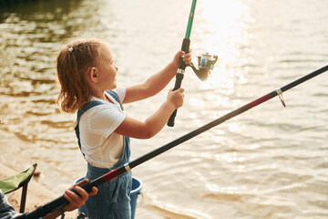 Little girl in casual clothes in on fishion outdoors at summertime
