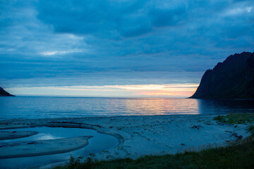 Fototapeta na wymiar Children, enjoying sunset on Ersfjord Beach on Senja island, beautiful landscape view over the mountains