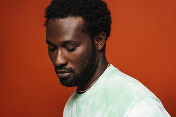 Obraz premium Young black man with beard posing and looking downward