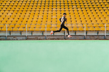Young white sportsman running while working out on stadium