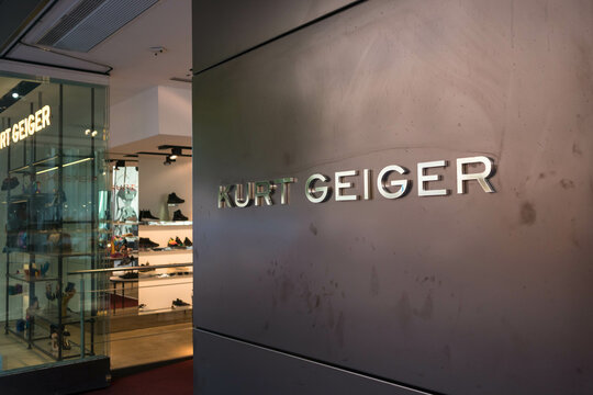 Entrance to Kurt Geiger designer fashion shop store showing goods and branding