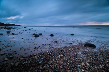 long exposaure sunset stones beach clouds windy