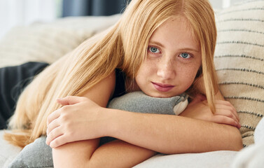 Obraz premium Portrait of female teenager with blonde hair that is at home at daytime