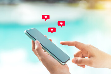 Close up woman hand hold using smart phone with heart icon at outdoor park street background. Copy space of technology business and travel holiday concept.