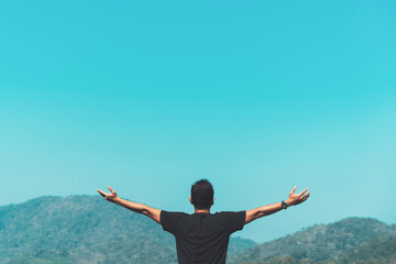 Copy space of man rise hand up on top of mountain and sunset sky abstract background.