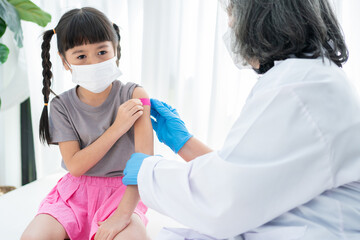 Doctor is affixing the medicinal plaster after vaccinated in shoulder of Asian girl kids in...