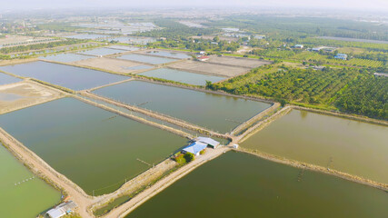 Aerial view of natural sea salt ponds, lake or sea. Farm field outdoor in traditional industry in Thailand. Asia culture. Agriculture irrigation. River reflection.