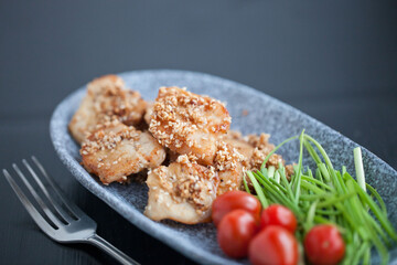 asian sesame chicken dish on a plate with garlic sprouts