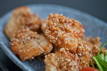 asian sesame chicken dish on a plate with garlic sprouts