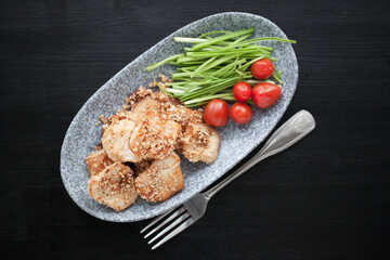 asian sesame chicken dish on a plate with garlic sprouts