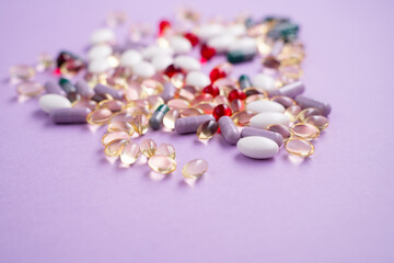 Vitamins and tablets in bulk on a pink background