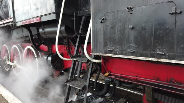 A retro steam locomotive prepares to leave the station.
