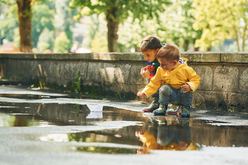 In the puddle. Kids having fun outdoors in the park after the rain