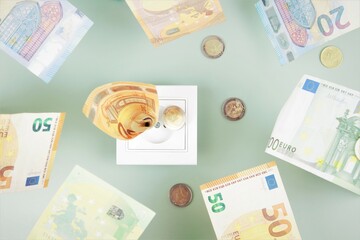 Euro money paper banknotes fall into a white electric socket on light green background. Increasing cost of electricity, expensive energy concept