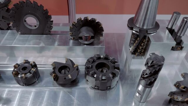 Set of new, modern, powerful cutters of industrial milling machine shown at the exhibition of metalworking equipment. Shot in motion. Closeup