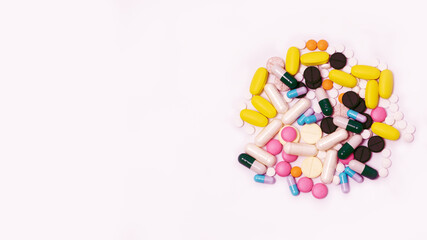 Variety of medicines and capsules in a woman's palm on a blue background. The concept of consuming a large number of drugs