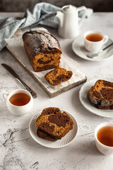 Homemade chocolate pumpkin cupcake with tea on a light gray background. Family tea party.