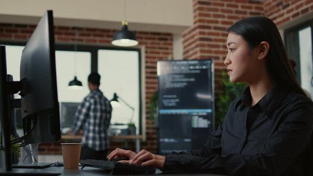 Portrait of programer writing algorithm smiling after successfuly compiling source code sitting at desk in software development office. Focused system engineer happy with parsing results