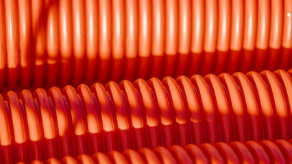 Red corrugated plastic tubes. Industrial background. Products from plastic. Drainage and sewerage....