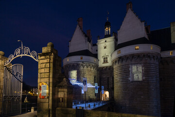 Entrée d'un château médiéval de nuit avec portail métallique et pont. Château des Ducs de...