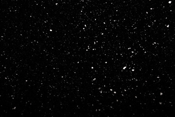 Falling snow freeze motion in the dark sky. Texture isolated on black background. Perfect for white snowflakes overlay, winter abstract