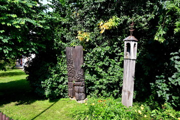A close up on two wooden shrines located in the middle of a public park next to some shrubs or...
