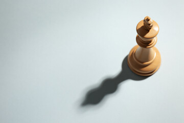 White wooden chess king on light grey background, above view. Space for text