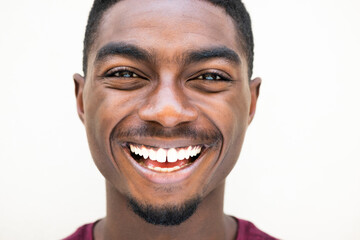 Close up happy young african American man laughing against white background